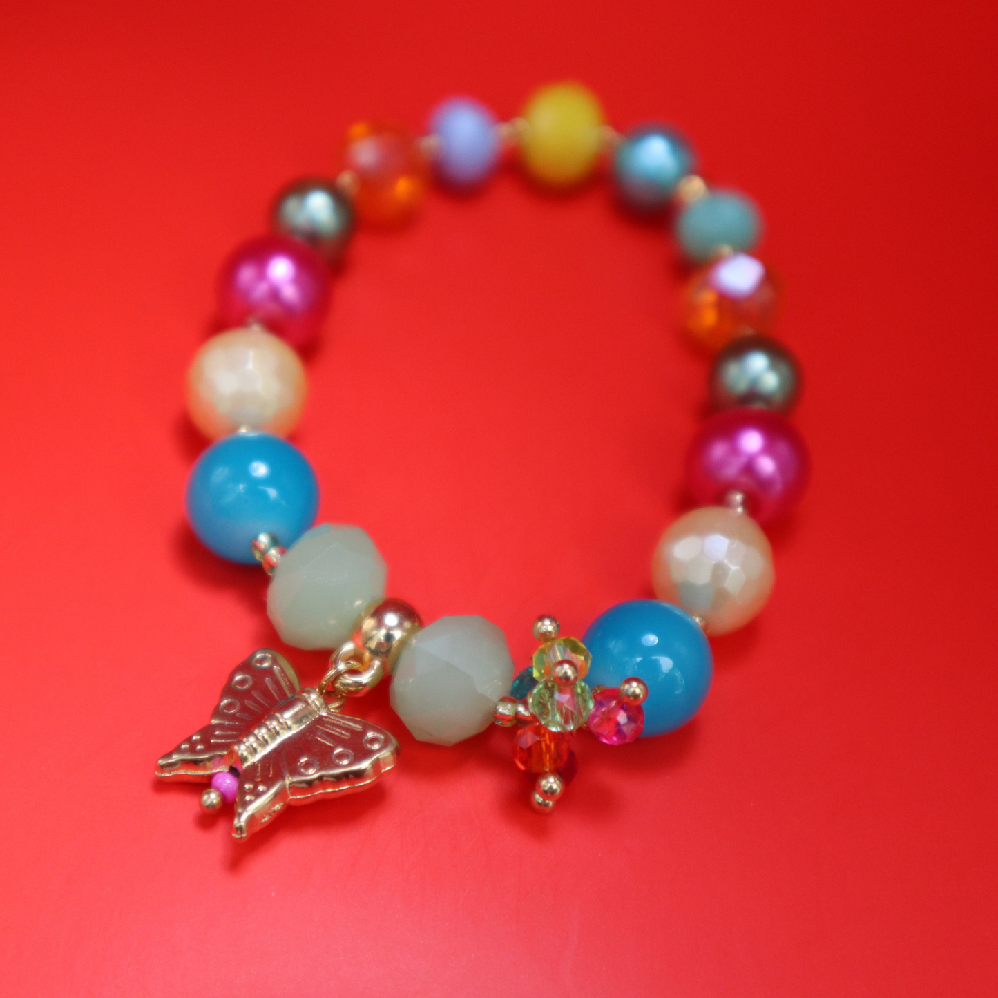 Alas de luz | pulsera elástica de colores con dije en forma de mariposa